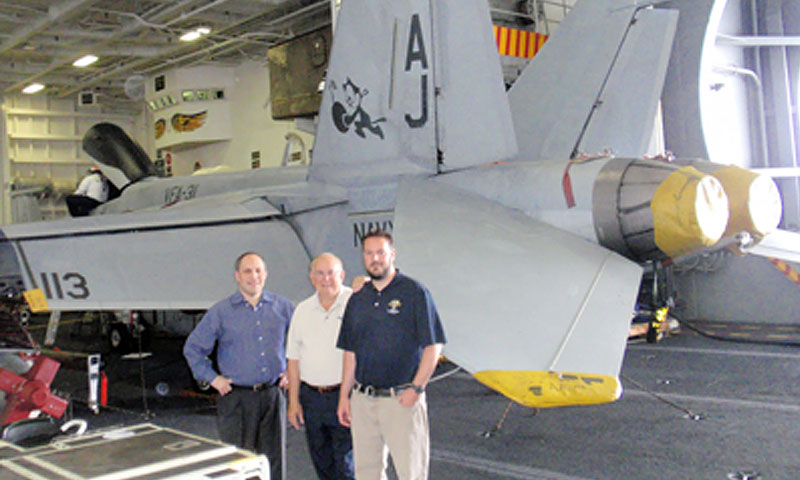 NPS’ Regional Security and Education Program Team, from left, Michael Ruben, Steve Loeffler and Matt DuPee in the hangar bay of the USS George H.W. Bush. The team delivered over 300 cultural presentations to sailors during a ten-day stay aboard the carrier.