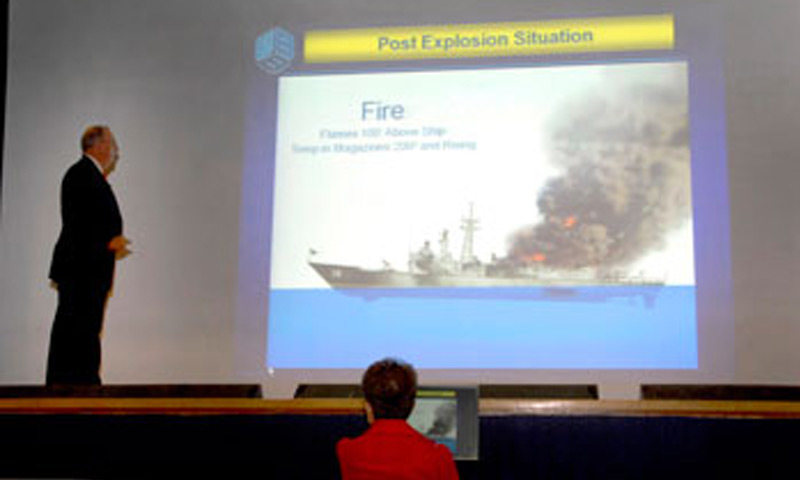 Retired Navy Capt. Paul Rinn, 1st Commanding Officer (CO) of the guided-missile frigate USS Samuel B. Roberts, shows an illustration of what the ship looked like after hitting a mine on April 14, 1988 at a Naval Postgraduate School Secretary of the Navy Guest Lecture Series, Aug. 3 in King Auditorium. Capt. Rinn was the CO of the Roberts when she struck a mine in the spring of 1988 while on escort duty in the Persian Gulf. 