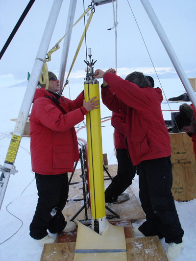 A team of researchers and NPS faculty practice lowering an ocean profiler into the ice shelf during a previous trip to Antarctica. The profiler is one of several pieces of equipment specially designed and built at NPS specifically for the current research trip.