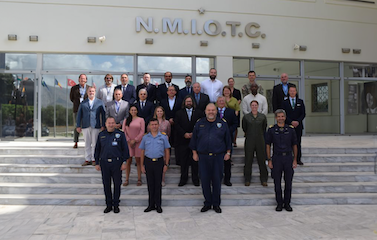 a picture of a group of participants and officers standing on the staircase in front of N.M.I.O.T.C. building