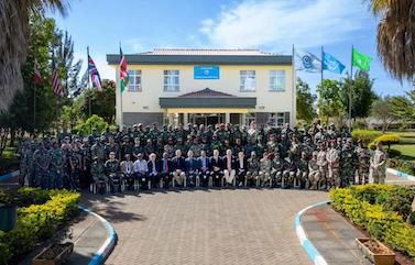 picture of participants along with soldiers standing in front of a building
