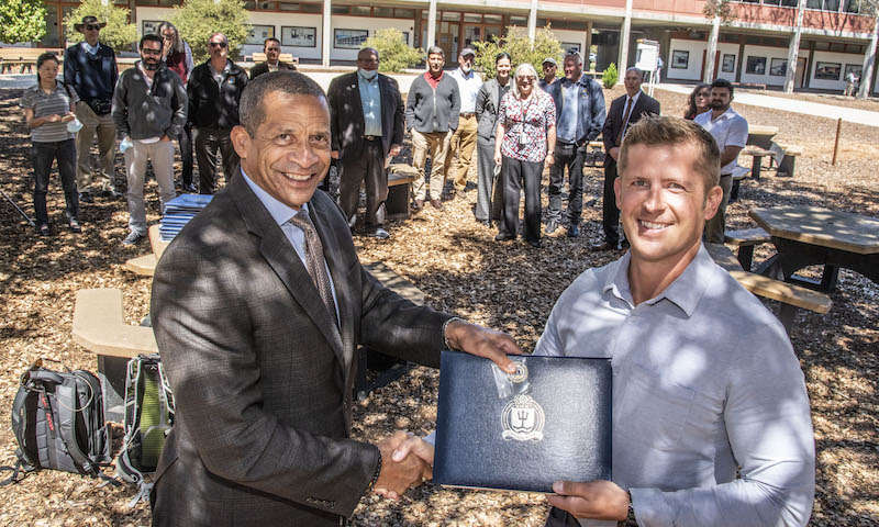 U.S. Air Force Maj. Dustin M. Merritt is presented with a certificate recognizing his graduation with distinction honors from the Naval War College Monterey program. 