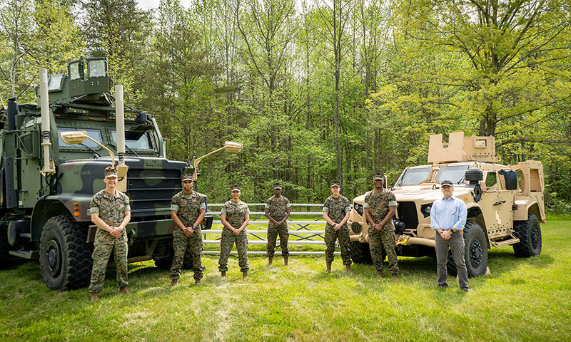 The Conditions-Based Maintenance Plus and Data Analytics team for Headquarters Marine Corps is pictured with the two weapons systems used